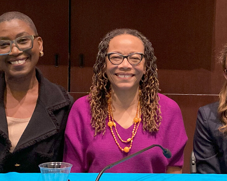 Three poeple smiling at the camera.