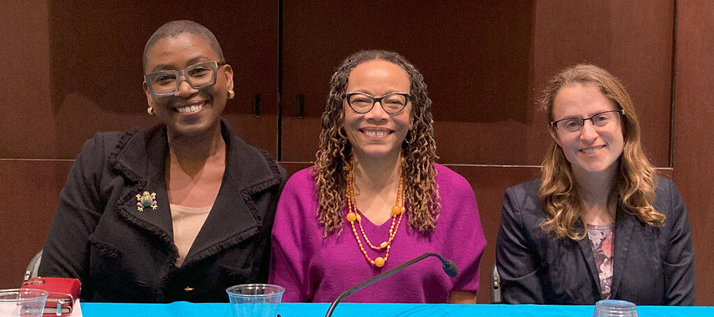 Three poeple smiling at the camera.